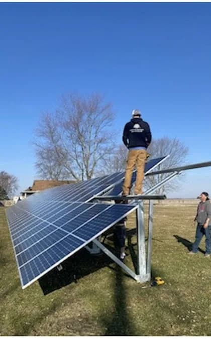A Solar Power Midwest crew building Jim's ground-mount solar array in his yard on a clear day.